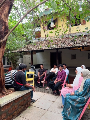 Kifayat members exchanging stories in a courtyard gathering